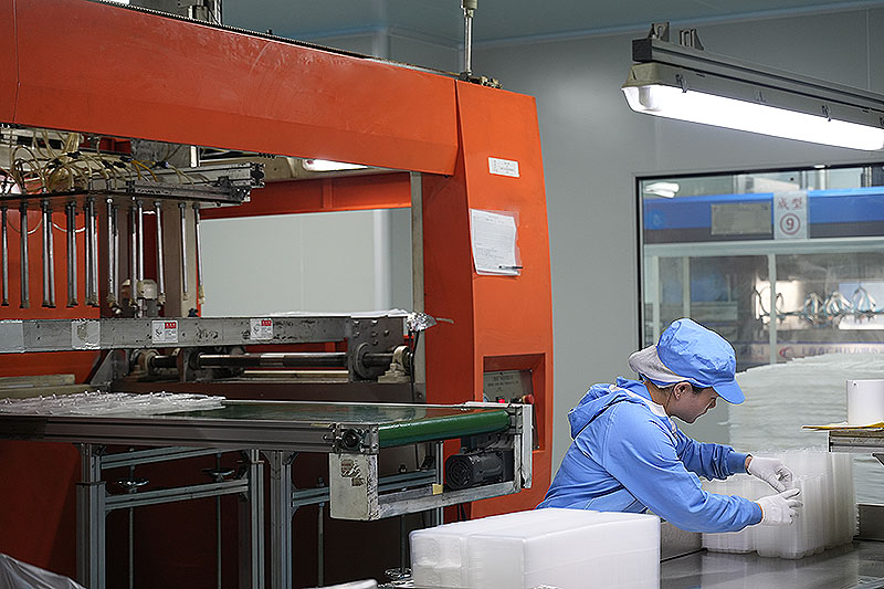 全自动吸塑机旁的包装工